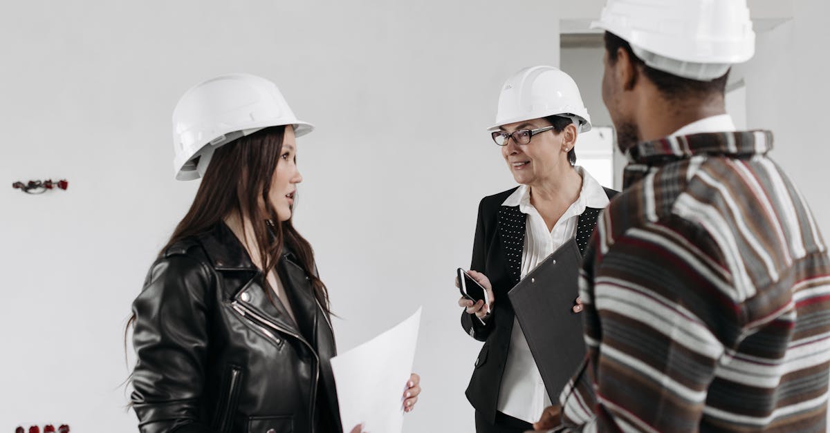 Professional team of architects in hard hats discussing project plans inside a building.