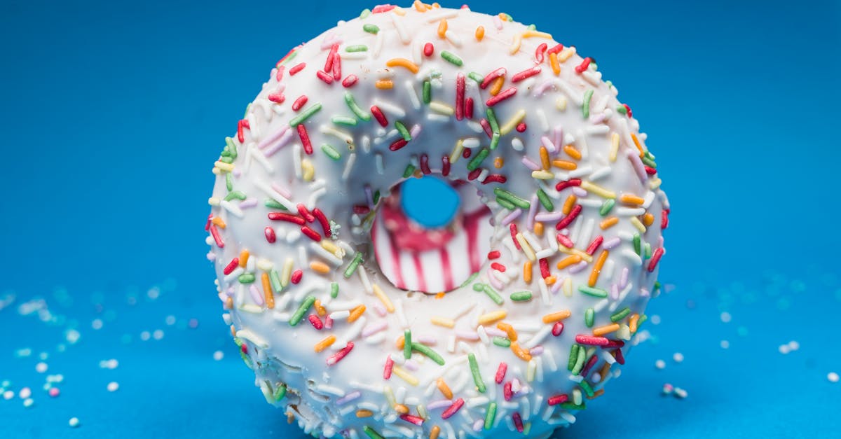 Colorful doughnut with sprinkles against a blue background, appealing and eye-catching.