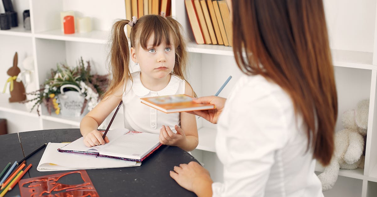 Young girl learning with a tutor at home, engaging with educational materials.