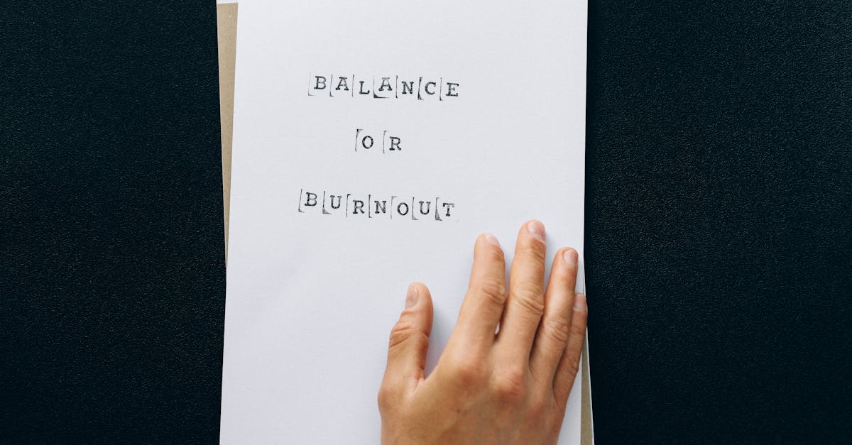 Hand holding paper with 'Balance or Burnout' text, promoting mental wellness.