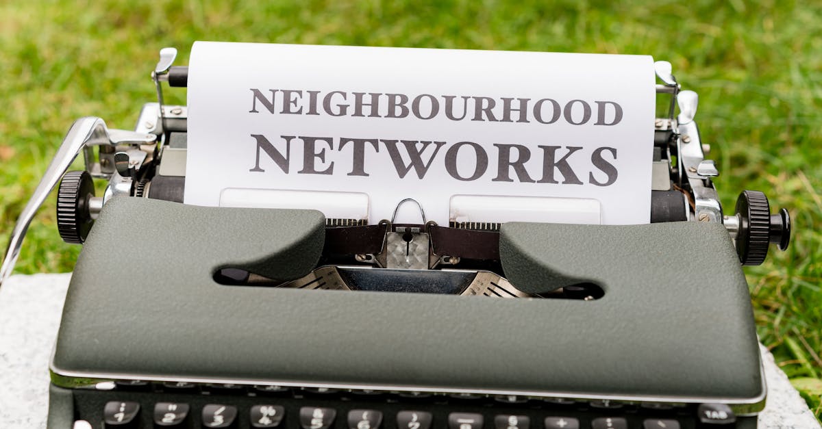 Retro typewriter displaying 'Neighborhood Networks' on paper, outdoors.