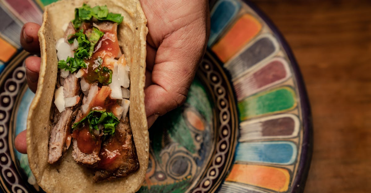 Close-up of a traditional Mexican taco with fresh ingredients on a colorful ceramic plate.