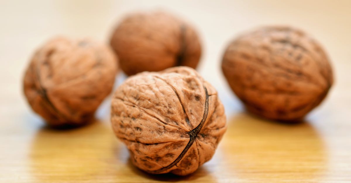 Macro shot of whole walnuts on a wooden surface, emphasizing texture.