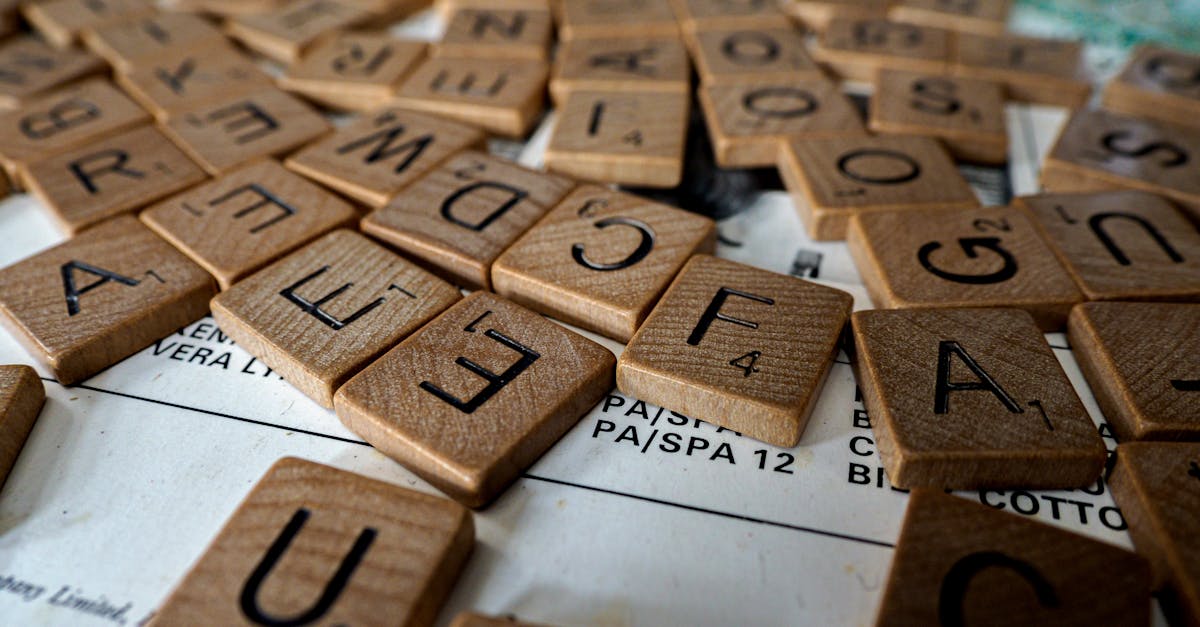 A close-up view of wooden Scrabble tiles scattered on a table, ideal for word games and educational themes.