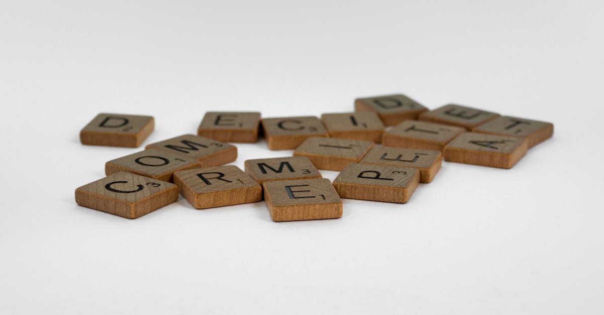 Close-up of wooden Scrabble tiles on a white surface, ideal for creative concepts.