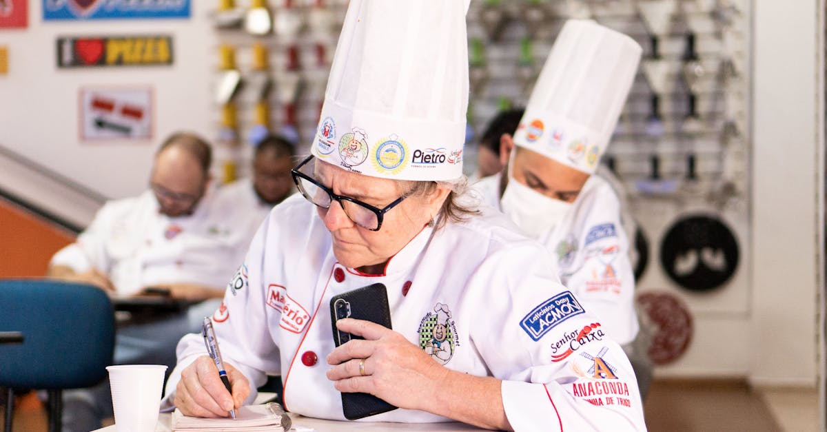 Chefs in a cooking class take notes and focus on learning new skills. Perfect for culinary themes.