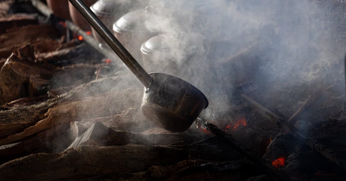 Steaming claypots cooking over an open wood fire in Vietnam, showcasing traditional culinary techniques.