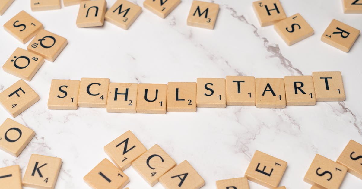 Wooden tiles forming the word 'Schulstart' on a marble surface, symbolizing school beginning.