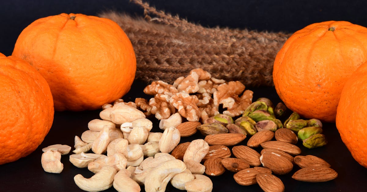 Vibrant oranges paired with assorted nuts on a sleek black background, showcasing a healthy snack option.