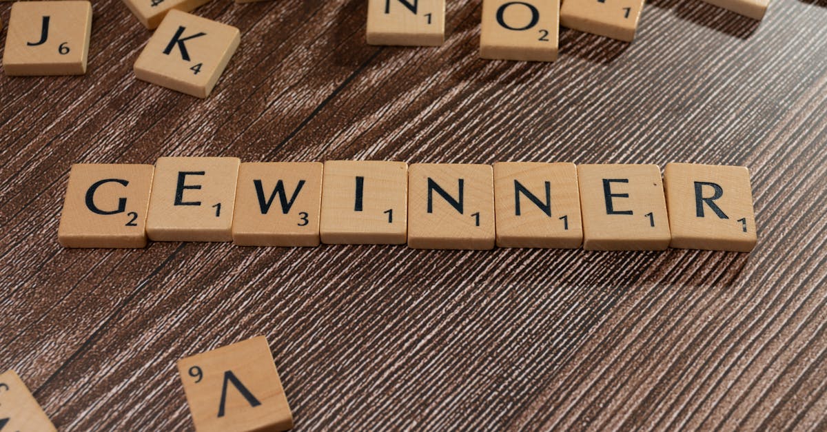 Scrabble tiles forming the word 'Gewinner' meaning winner on a wooden table.