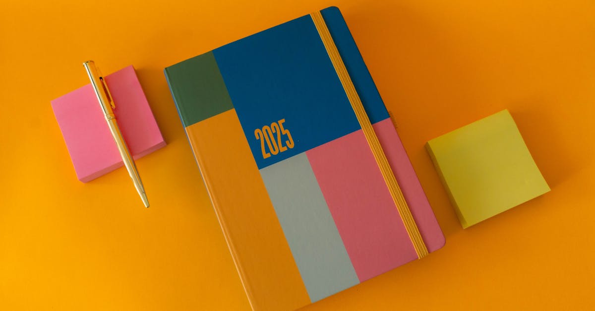 Vibrant 2025 planner and pen arrangement with colorful sticky notes on an orange surface.