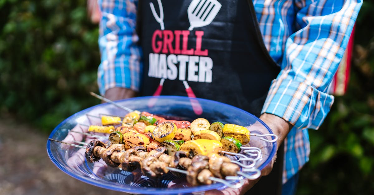 A Grill Master holding a plate of colorful grilled vegetable skewers outdoors.