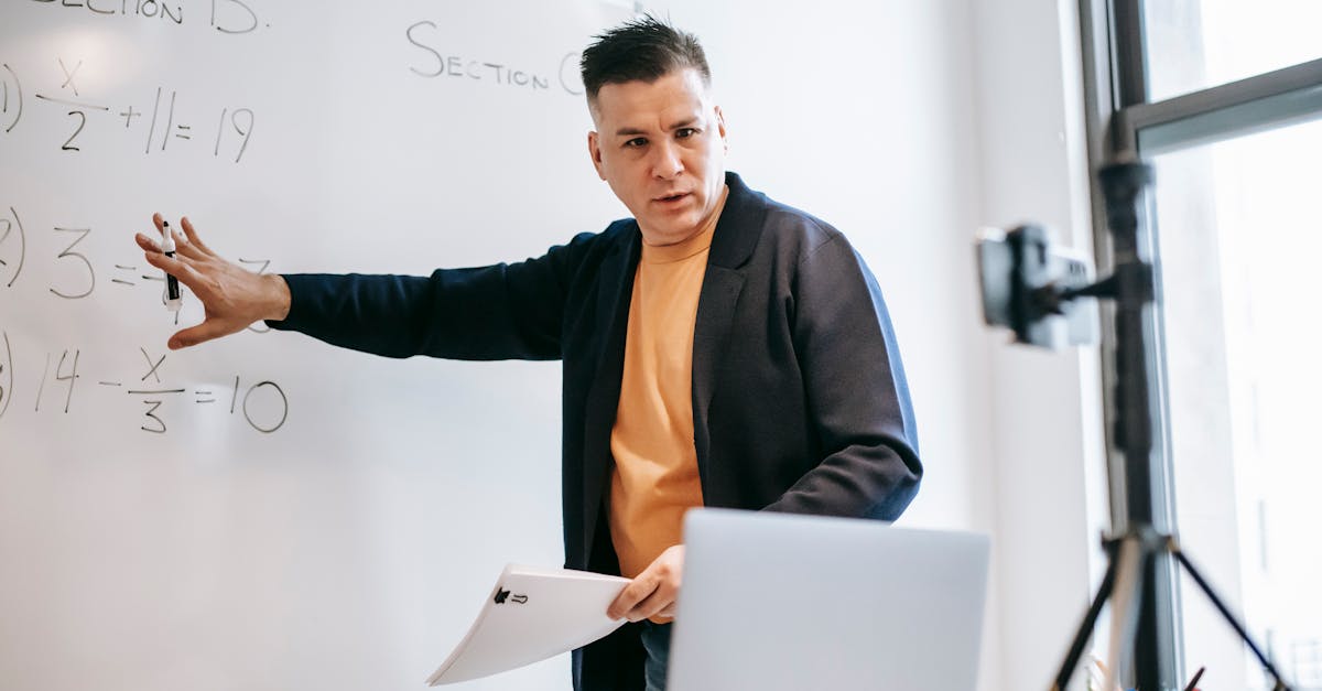 Professional instructor teaching math concepts online with a laptop and whiteboard.