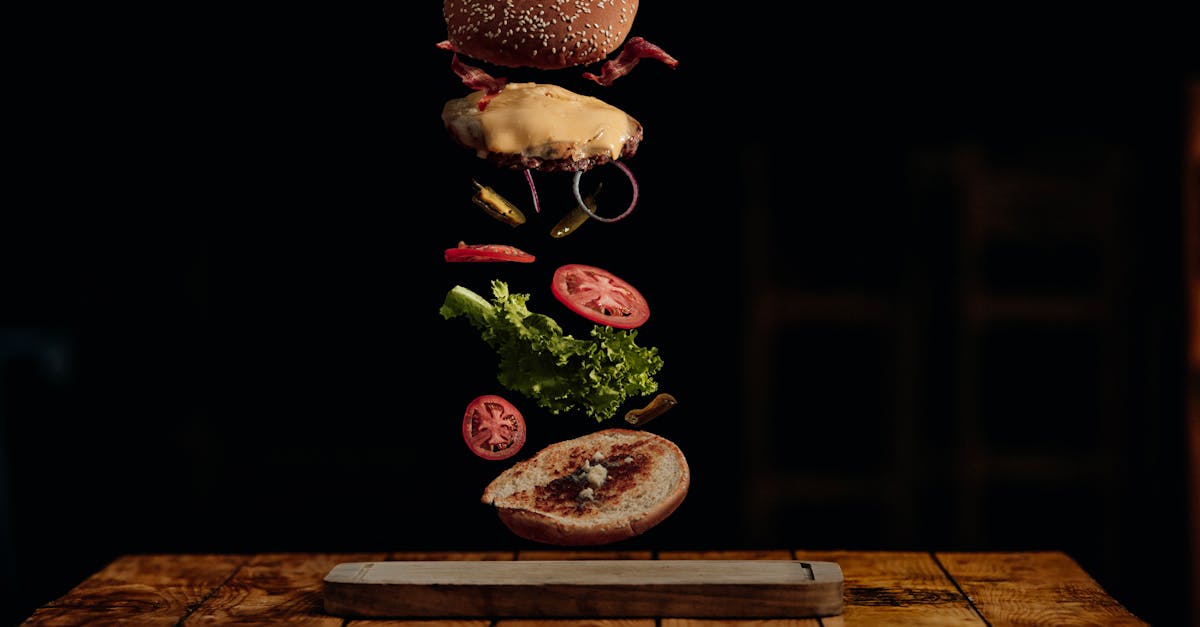 Visually striking deconstructed burger with floating ingredients in a dark background.