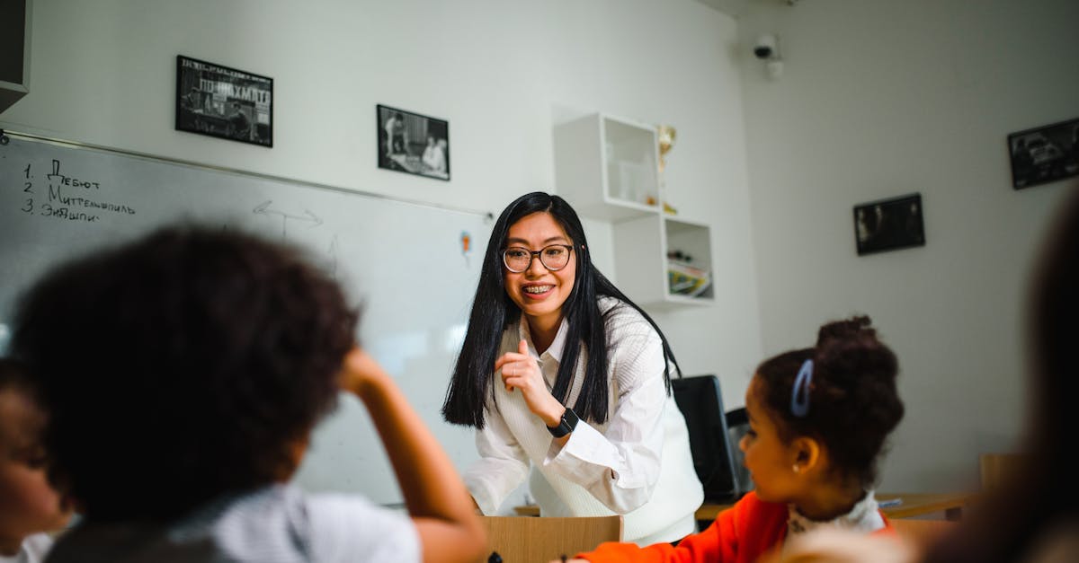 A teacher interacts with children during a chess lesson in a classroom setting.