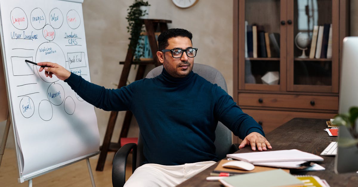 Man teaching online, pointing at a flipchart in a cozy office space. Perfect for online education themes.