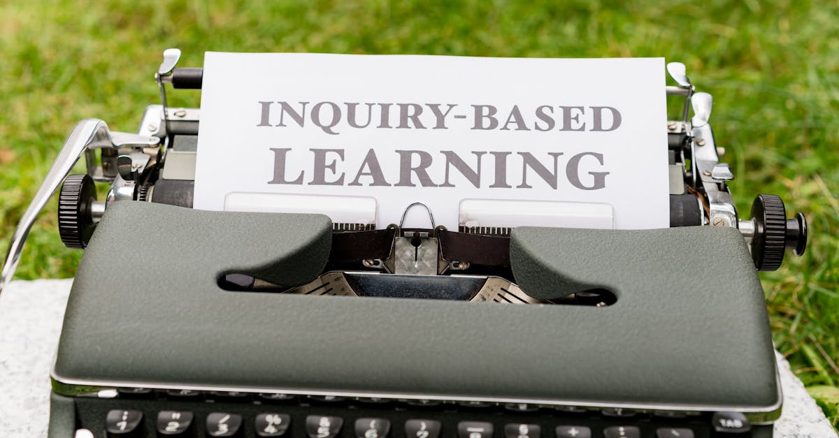 Close-up of a vintage typewriter with paper labeled 'Inquiry-Based Learning' outdoors.