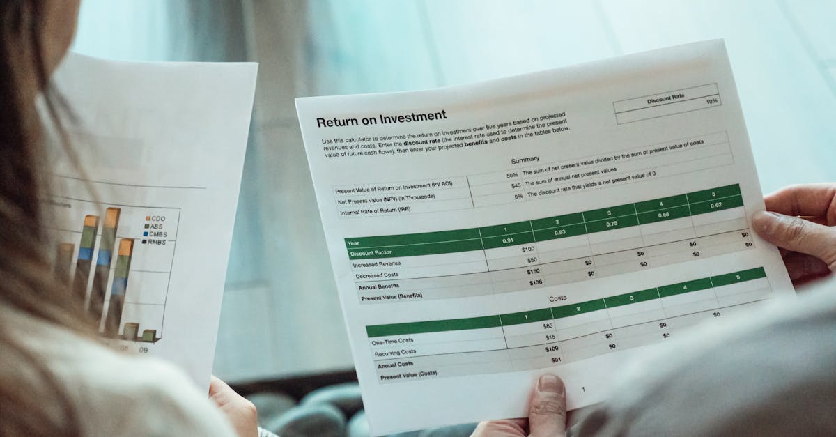 Close-up of two individuals analyzing financial documents related to return on investment.