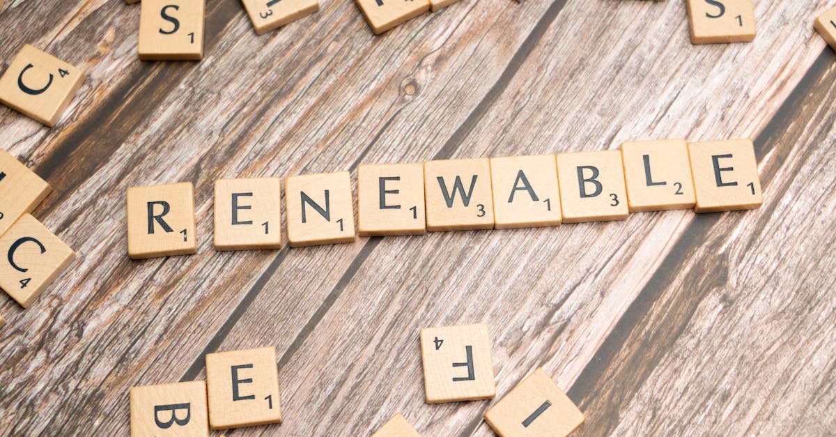 Wooden Scrabble tiles on a wooden table spell 'Renewable' emphasizing sustainability.