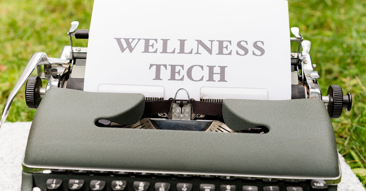 A retro typewriter outdoors displaying a 'Wellness Tech' message on paper.