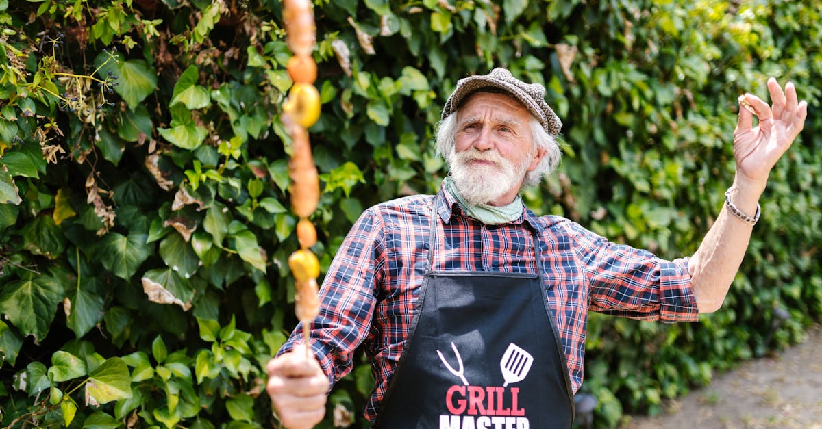 Elderly man enjoying grilling in backyard with skewer and apron.