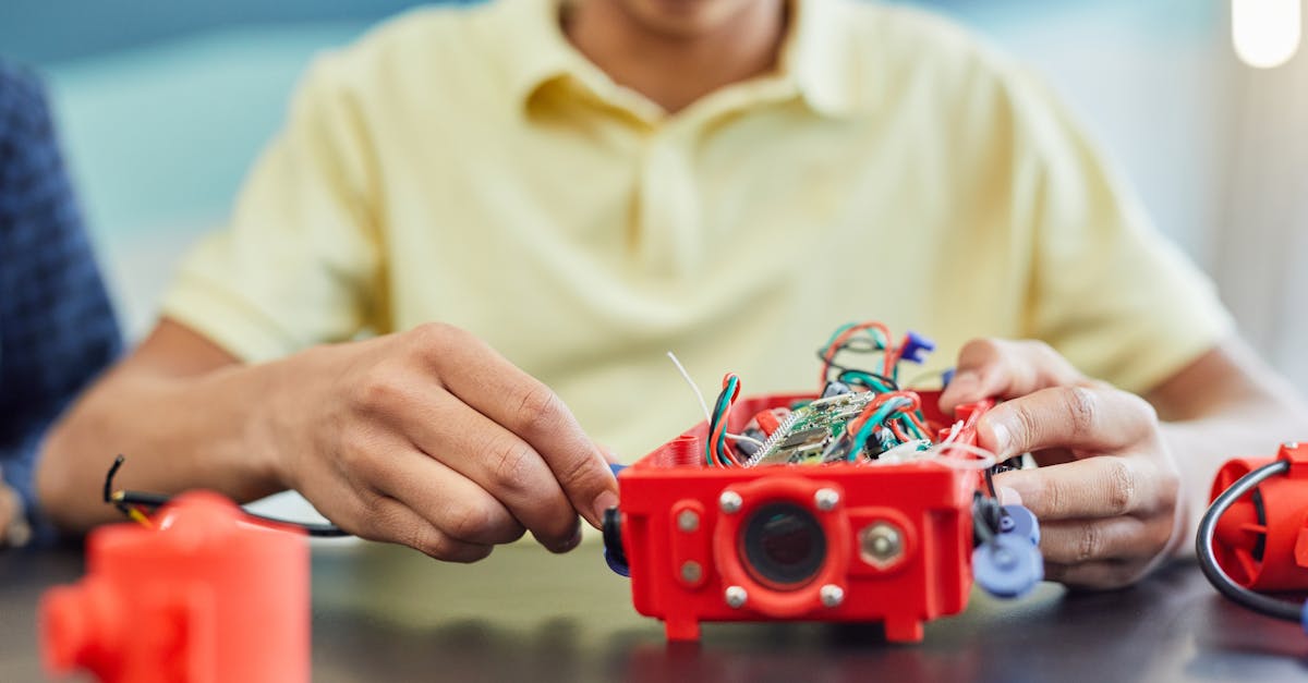A teenager works on assembling a robotic project, showcasing innovation and creativity.