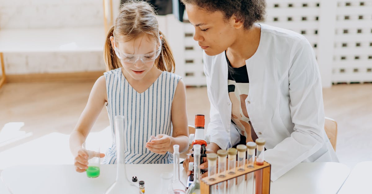 A teacher assists a child in a science experiment with test tubes in a classroom setting.