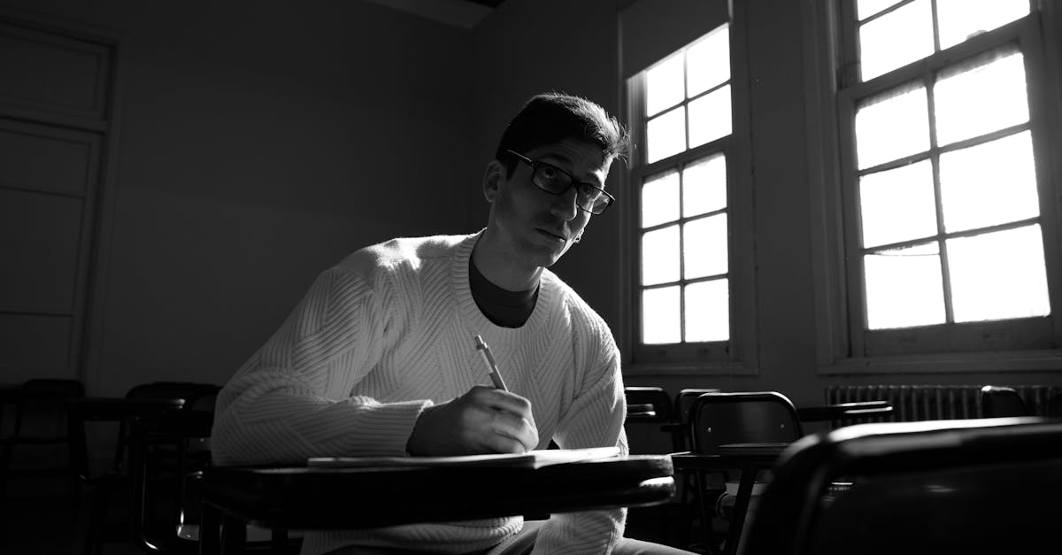 University student writing in a classroom with dramatic lighting in Buenos Aires.