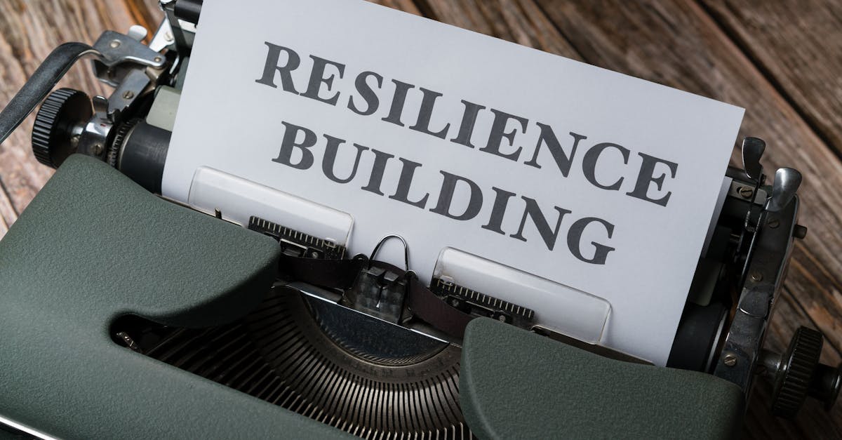 A vintage typewriter with the words 'RESILIENCE BUILDING' on a paper sheet.