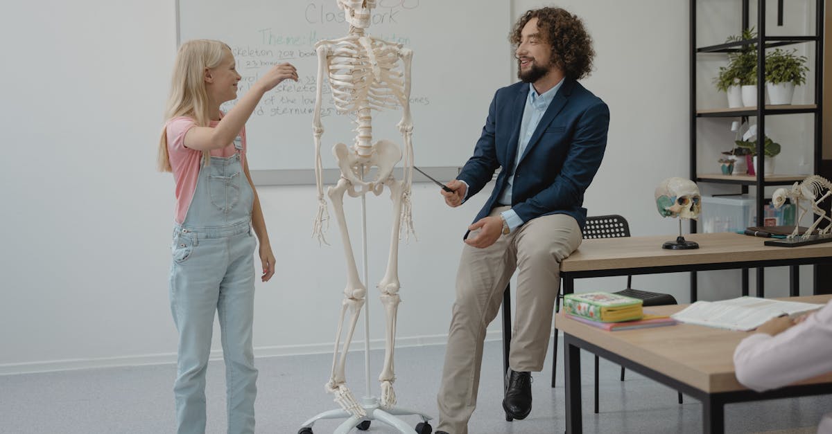 Teacher and student interact with a skeleton model during a lively biology lesson in a classroom.
