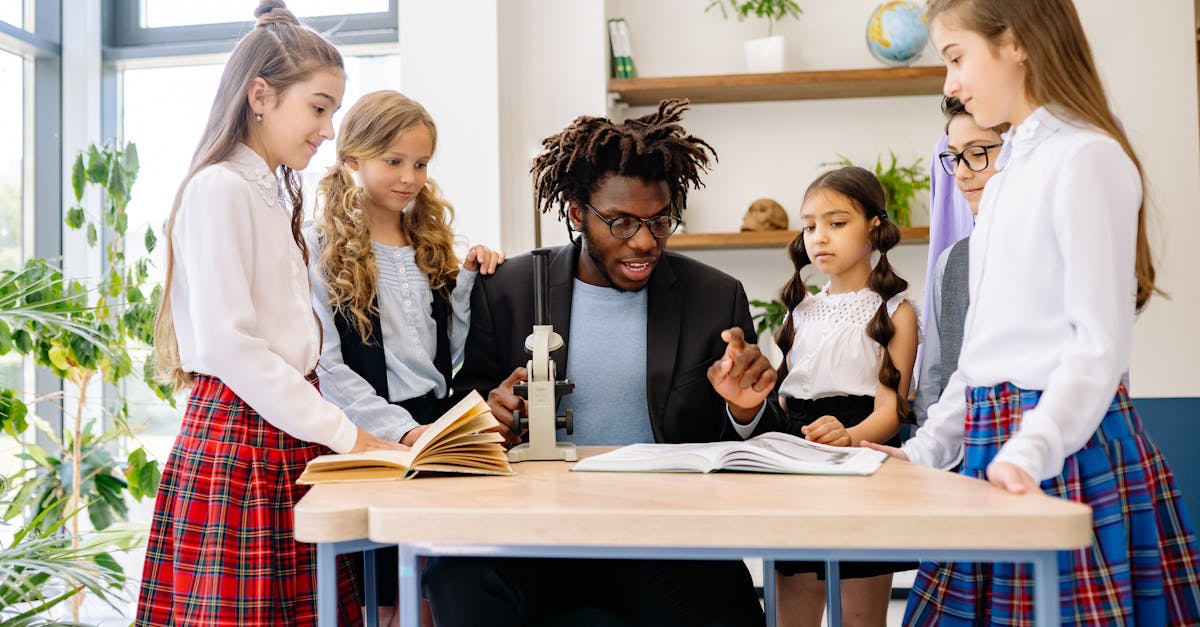 Teacher and diverse group of students in school setting, learning with books and microscope.