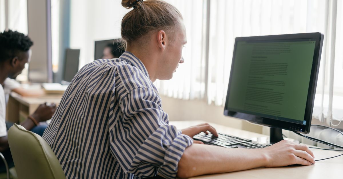 Focused student working on a computer in a bright, modern study space.