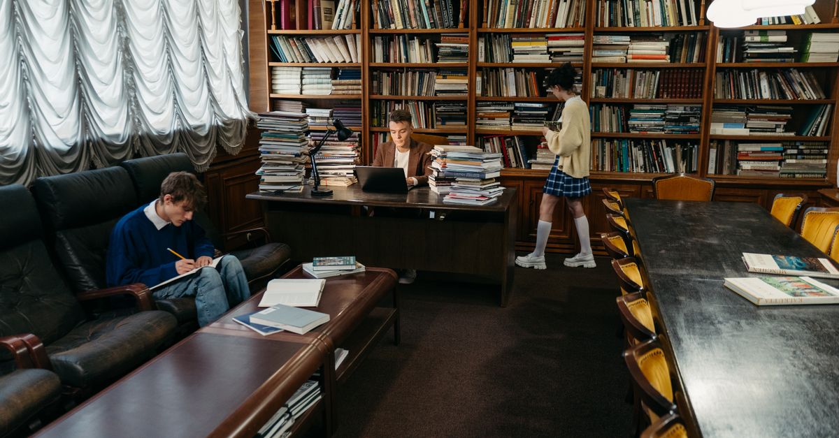 Students engaging in study and research within a classic library setting.